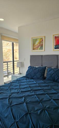a bedroom with a blue comforter on a bed at Elegant Condo in an Upscale Building in Cabo San Lucas