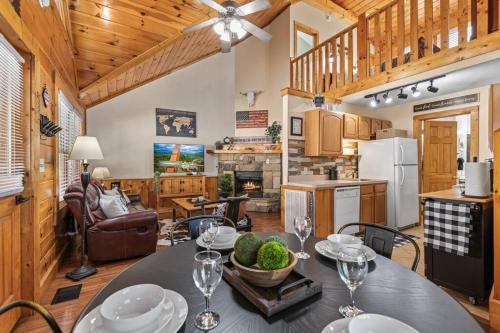 a kitchen and dining room with a table with wine glasses at Cozy Cabin in the Smokies!!! Fully Furnished and complete with community indoor and outdoor pools and spas, game and fitness rooms as well as a private Hot Tub in Pigeon Forge