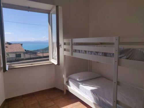 een slaapkamer met een stapelbed en een groot raam bij Locanda Maddalena - Accoglienza Pellegrini in Montefiascone