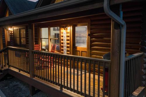 a deck of a log cabin with chairs on it at Cozy Cabin in the Smokies!!! Fully Furnished and complete with community indoor and outdoor pools and spas, game and fitness rooms as well as a private Hot Tub in Pigeon Forge