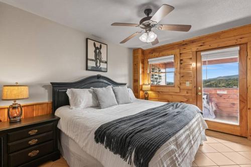 a bedroom with a bed and a ceiling fan at Cozy Cabin in the Smokies!!! Fully Furnished and complete with community indoor and outdoor pools and spas, game and fitness rooms as well as a private Hot Tub in Pigeon Forge
