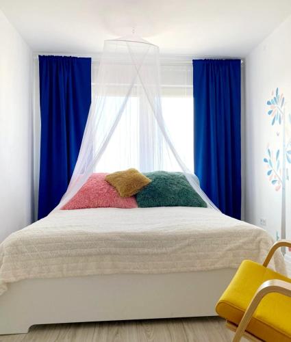 a bedroom with a bed with colorful pillows on it at Seaview Flat in Liepāja