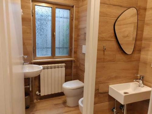 bagno con servizi igienici, lavandino e specchio di Locanda Maddalena - Accoglienza Pellegrini a Montefiascone