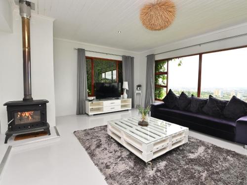 sala de estar con sofá negro y chimenea en Cloud59, en Tygerberg Hills