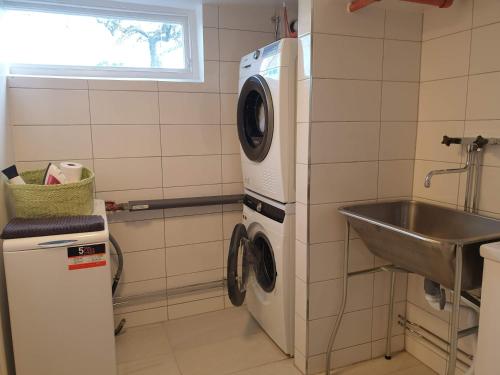 a kitchen with a washing machine and a sink at Spacious and cozy semi-basement in Lund