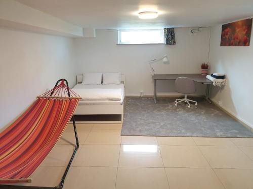 a bedroom with a bed and a desk and a hammock at Spacious and cozy semi-basement in Lund