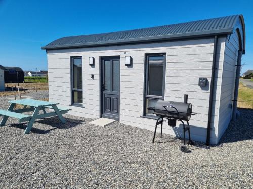 a trailer with a picnic table and a grill at Easkey Glamping Village in Easkey