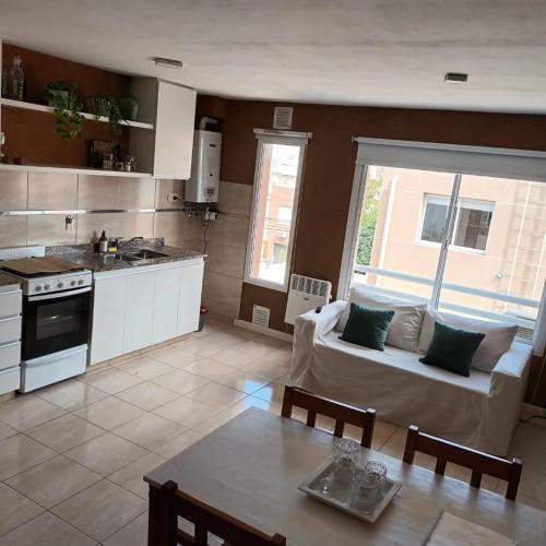 a kitchen and living room with a couch and a table at Bahia Blanca Estudio con Estacionamiento in Bahía Blanca
