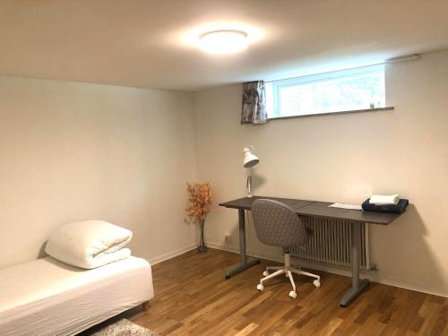 a bedroom with a desk and a bed and a desk and chair at Spacious and cozy semi-basement in Lund