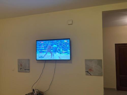 einen Flachbild-TV, der an einer Wand hängt in der Unterkunft Alpha house in Ndangane