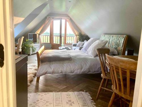 um quarto com uma cama, um sofá e uma janela em The Nest BnB 'mini suite' Dorchester on Thames em Dorchester on Thames