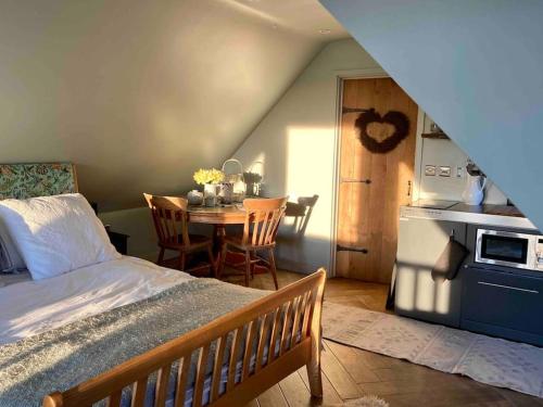 um quarto com uma cama e uma cozinha com uma mesa em The Nest BnB 'mini suite' Dorchester on Thames em Dorchester on Thames