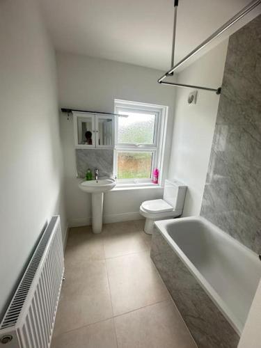 La salle de bains est pourvue d'une baignoire, de toilettes et d'un lavabo. dans l'établissement Gladstone House, à Bournemouth