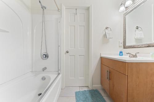 a white bathroom with a tub and a sink at Villas On The Gulf L1- Ocean view steps to beach! in Pensacola Beach