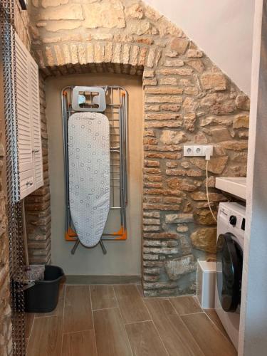 um quarto com uma parede de pedra e um frigorífico em Casa de La Serra em Montblanc