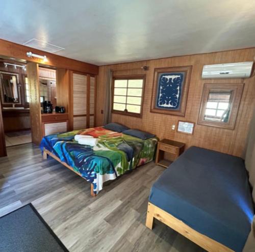 a bedroom with a bed and a table in it at Vahaui Paradis in Avatoru