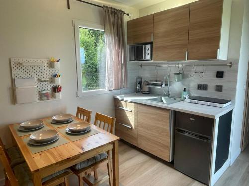 a kitchen with a wooden table and a kitchen with a sink at Przytulny domek na Mazurach - Jeziorowskie k. Kruklanek in Jeziorowskie