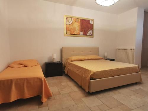 een slaapkamer met 2 bedden en een foto aan de muur bij Intera casa appena ristrutturata in Parabita