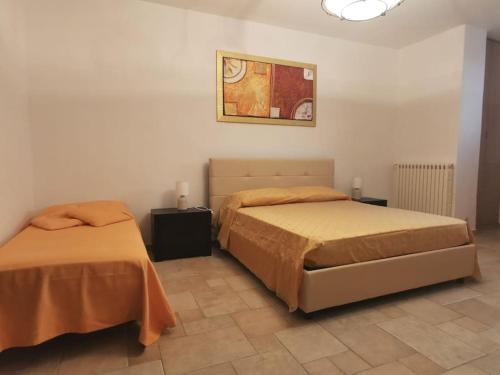 a bedroom with two beds and a picture on the wall at Intera casa appena ristrutturata in Parabita
