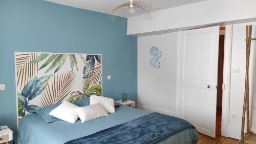 een slaapkamer met blauwe muren en een bed met kussens bij Bulles d'Evasion in Avize