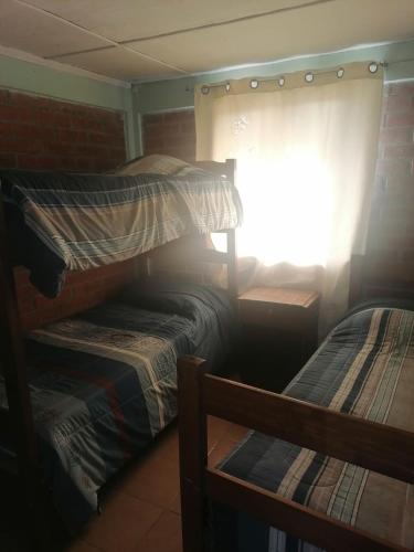 a bedroom with two bunk beds and a window at Cabaña Carretera internacional in Los Andes