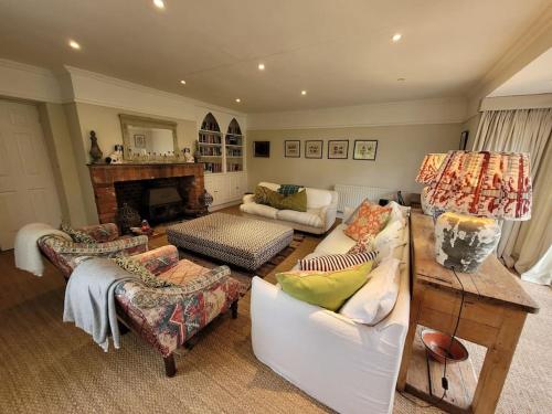 sala de estar con muebles y chimenea en Old school house surrounded by countryside en Earls Colne