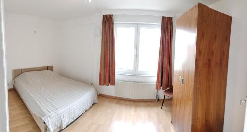 a small bedroom with a bed and a window at Project 9 in Ostend