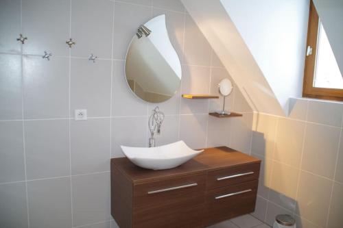une salle de bain avec un lavabo et un miroir dans l'établissement Maison de village à 5 minutes de St Lary Soulan, à Saint-Lary-Soulan
