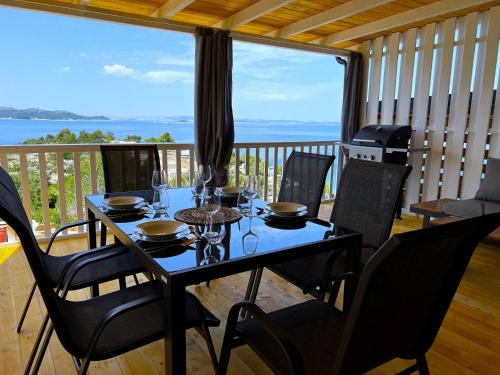 a table with wine glasses on it on a balcony at Mobile Home SkyLine - beautiful sea view - on the palm of the beach in Drage