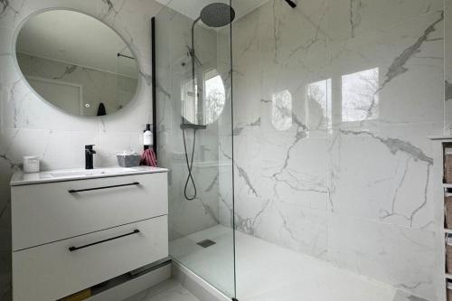 une salle de bain avec une douche avec un lavabo et un miroir dans l'établissement Villa Lorenssia entre Paris et Disney avec jacuzzi, à Lésigny