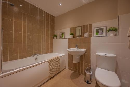 a bathroom with a toilet and a sink and a bath tub at 14 Castlegate, Tutbury in Tutbury