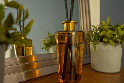 a gold vase sitting on a table with potted plants at 14 Castlegate, Tutbury in Tutbury