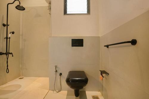 a bathroom with a black toilet and a shower at Wabi Sabi Resort , Igatpuri in Wādhiware
