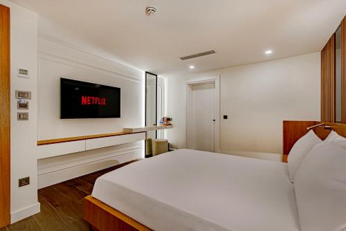 a bedroom with a bed and a tv on the wall at Dulcet Hotel in Antalya
