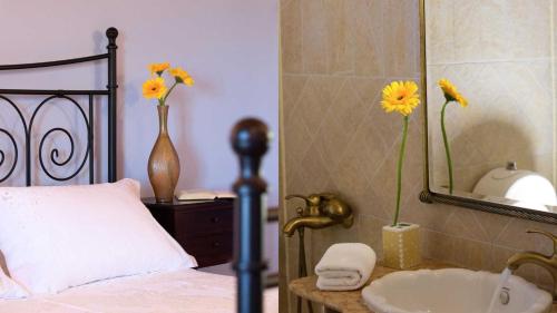 a bedroom with a bed and a sink and a mirror at Theasis Villas in Lygia