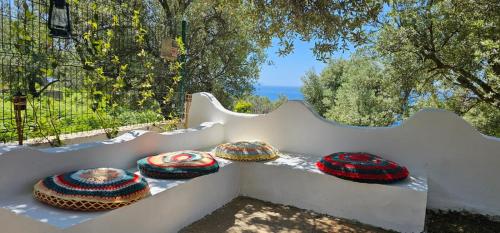 a group of pillows sitting on a white bench at Villa Ermis in Dhërmi