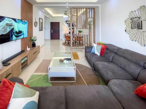 a living room with a couch and a table at Serenity Haven - Gated Pool WiFi Sea View in Agblesia