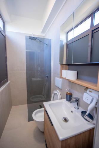 Un baño con lavabo, inodoro y ducha. en Hotel Pepe, en Shkodër