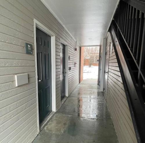 an empty hallway of a building with a green door at Aksarben Gem- WFH corner desk & minutes from I-80 in Omaha