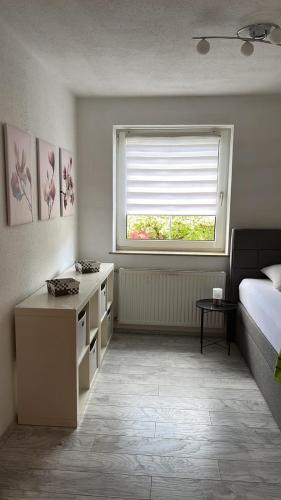 a bedroom with a bed and a window and a desk at Charmantes Ferienhaus - Velden in Fahrendorf