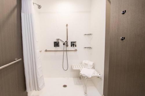 uma casa de banho branca com um chuveiro e um WC. em Courtyard by Marriott Mesa at Wrigleyville West em Mesa