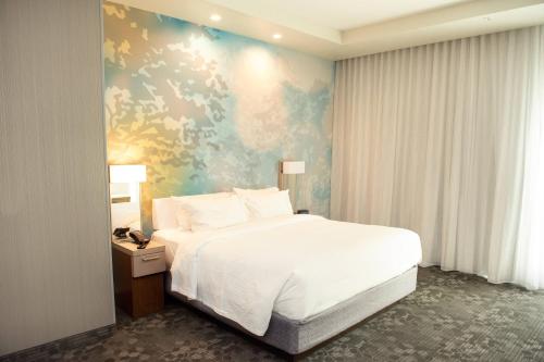 1 dormitorio con cama blanca y pared azul en Courtyard by Marriott Mesa at Wrigleyville West, en Mesa