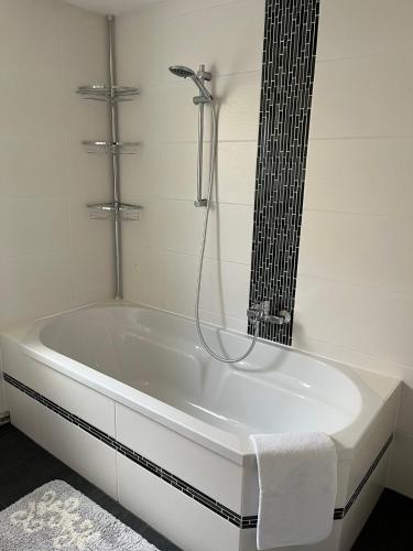 a white bath tub in a bathroom with a shower at Charmantes Ferienhaus - Velden in Fahrendorf