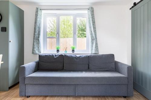 a couch in a living room with a window at Salisbury Guest Ąnnex in Salisbury