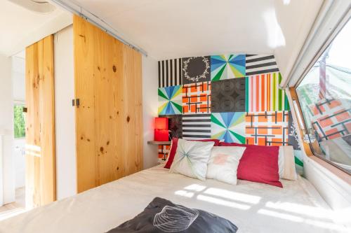 Habitación con cama y pared colorida. en Caravana-glamping Casa Tortuga, en La Nucía