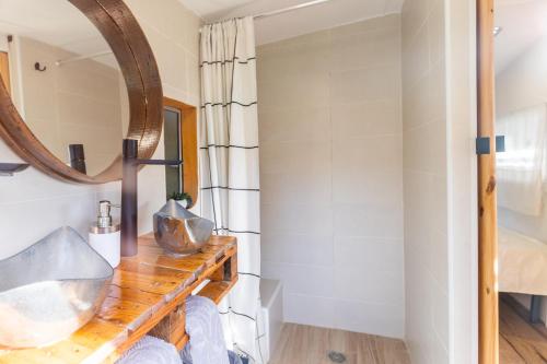 a bathroom with a mirror and a wooden shelf at Caravana-glamping Casa Tortuga in La Nucía