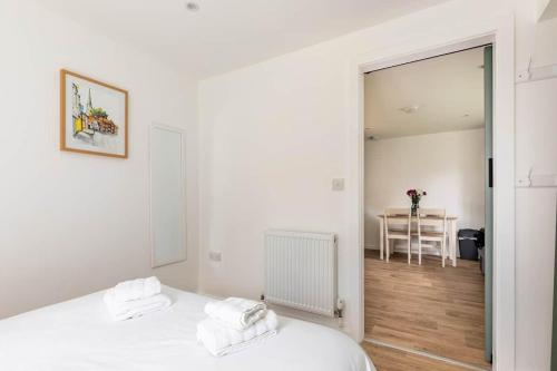 a white bedroom with a bed and a table at Salisbury Guest Ąnnex in Salisbury