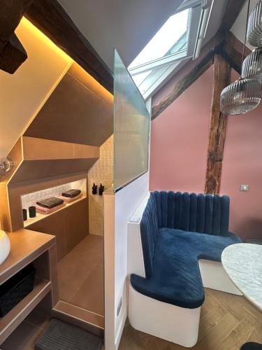 une chambre avec un banc bleu et une table dans l'établissement Nid d'amour sous les toits !, à Honfleur