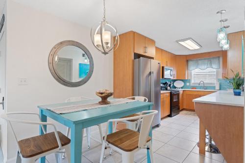 a kitchen with a blue table and chairs at Villas On The Gulf L1- Ocean view steps to beach! in Pensacola Beach