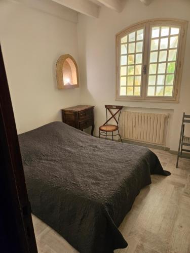 - une chambre avec un lit, une fenêtre et une chaise dans l'établissement Maison au Paradou, à Paradou